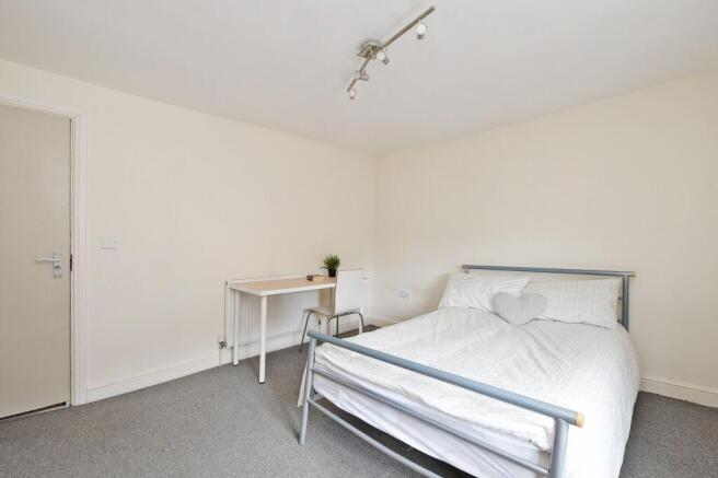Bright, simply furnished double bedroom with a ...