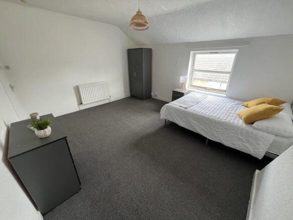Bright and spacious double bedroom featuring a ...