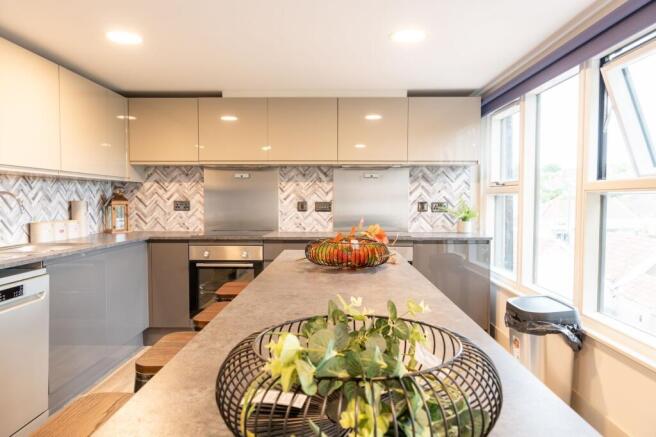 Bright modern kitchen with a long central islan...