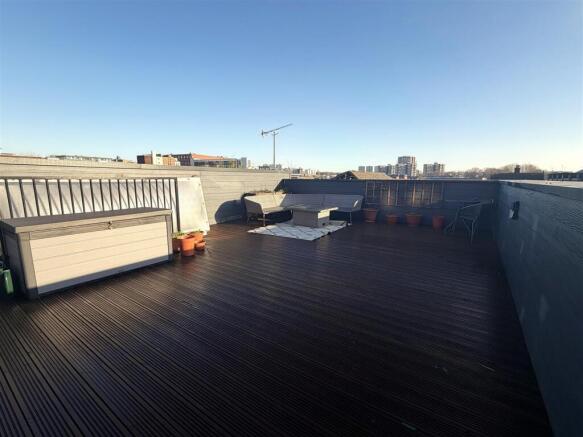 Expansive sun-drenched roof terrace with seatin...