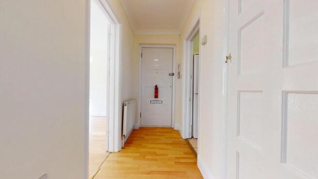 Bright and tidy hallway with warm wood floors...