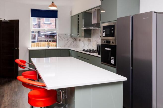 Modern kitchen with a long white island breakfa...