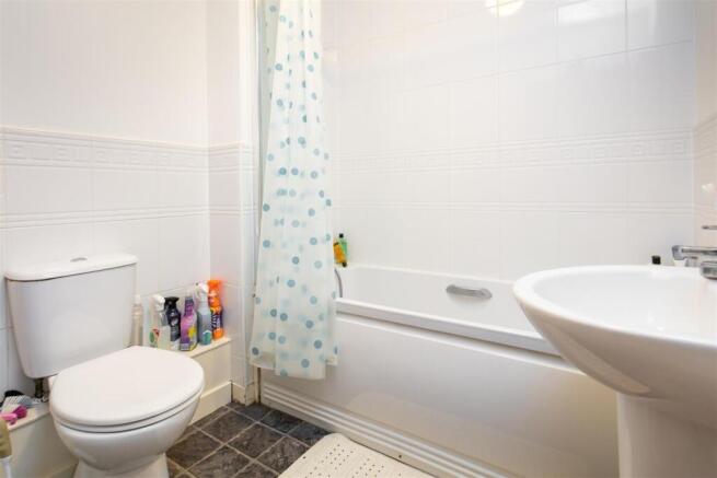 Bright, clean bathroom with a white bathtub, pe...
