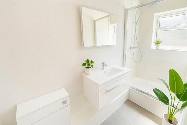 Modern bright bathroom with sleek walk-in showe...