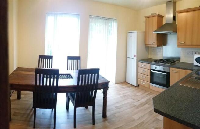 Bright kitchen with dining area featuring a woo...