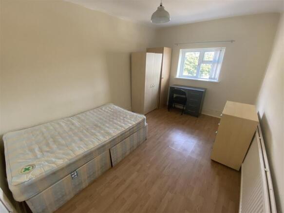 Bright, tidy bedroom with desk and ample storag...