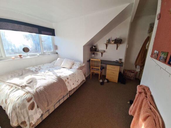 Cozy single bedroom featuring a large window th...