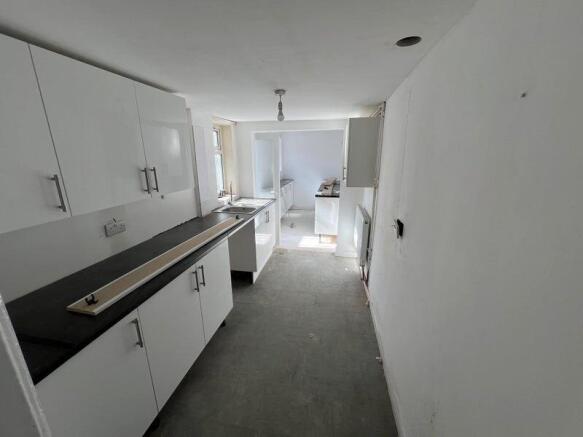Bright kitchen featuring white cabinetry and bl...