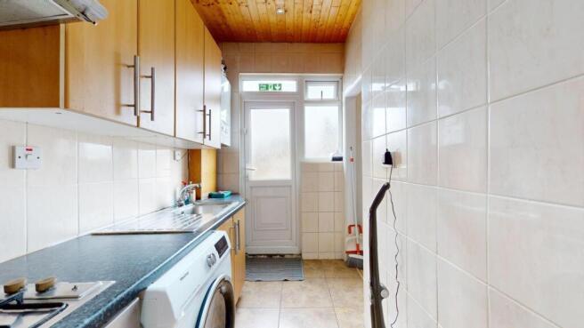 Bright galley kitchen with warm wood cabinetry,...