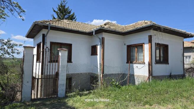 White house with metal gate entrance and garden area in Dolets village