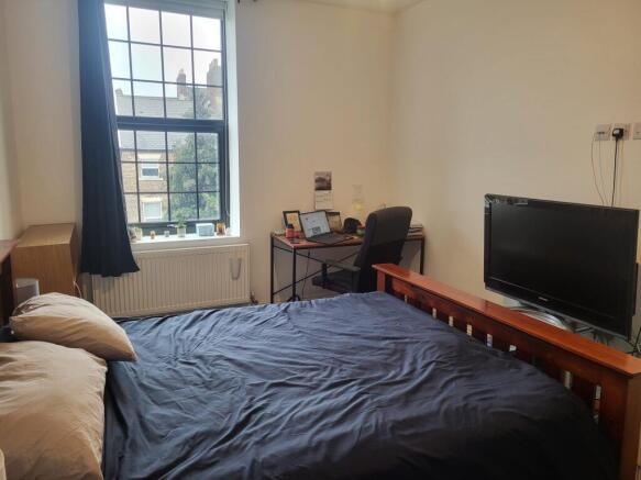 Bright double bedroom with a large window, comf...