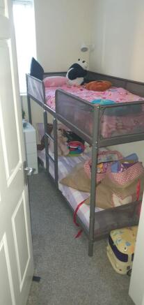 Bright compact bedroom with a metal bunk bed, f...