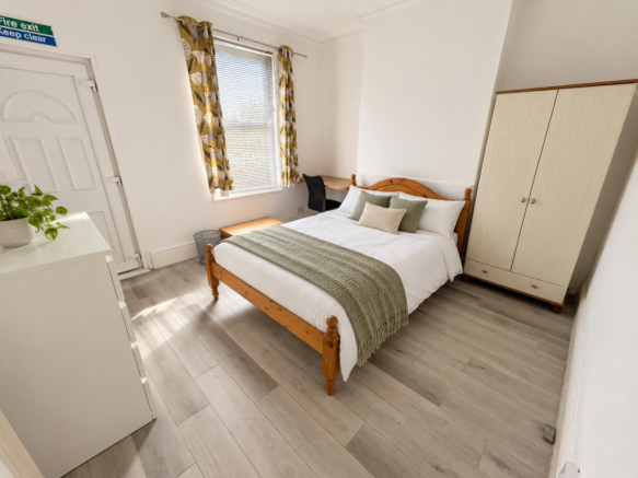 Bright bedroom with sage bedding and greenery-5.pn