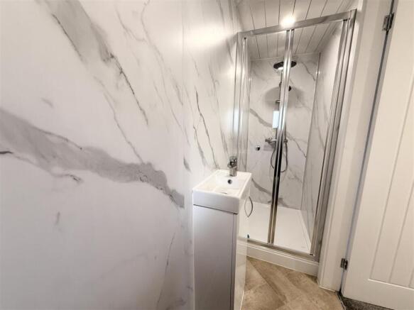 Elegant marble-effect shower room with sink...
