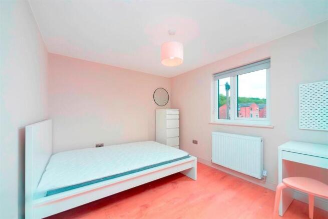 Bright, neat bedroom with bed and desk...
