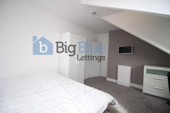 Bright and cozy master bedroom featuring a comf...