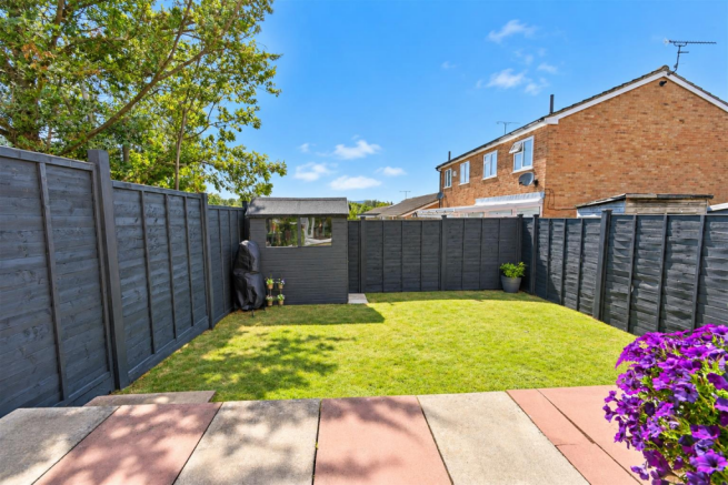 Sunny Charcoal-Fenced Garden with Shed.png
