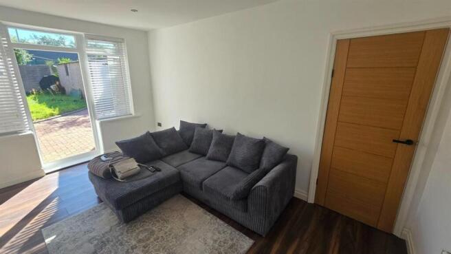 Bright living space with sofa and garden access...