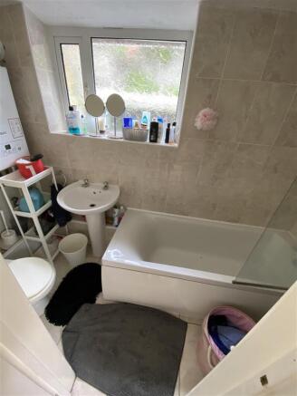 Bright tiled bathroom with a full-sized bathtub...