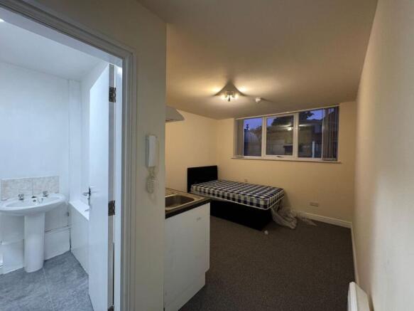 A cozy bedroom featuring a large window allowin...