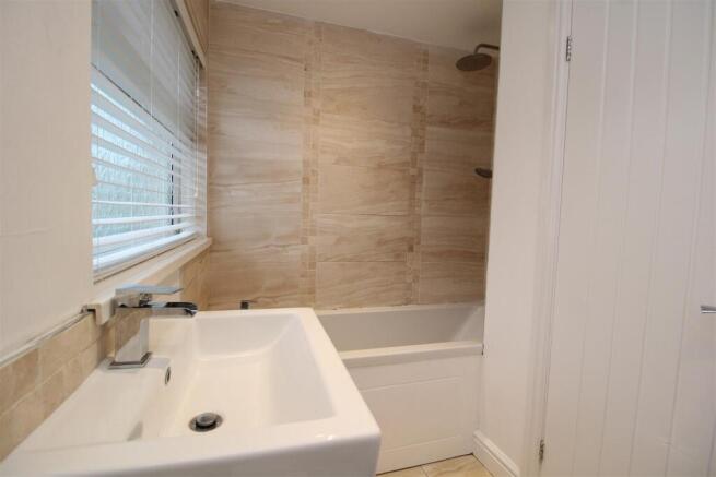 Modern bathroom with elegant tiling and full ba...