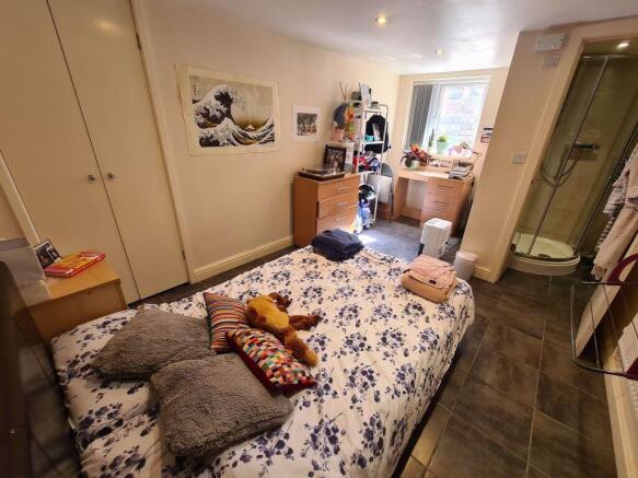 A cozy master bedroom featuring a comfortable d...