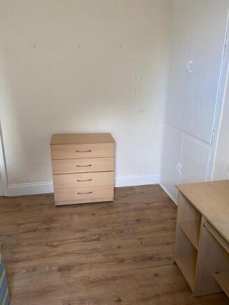 Bright bedroom with wood flooring and storage...