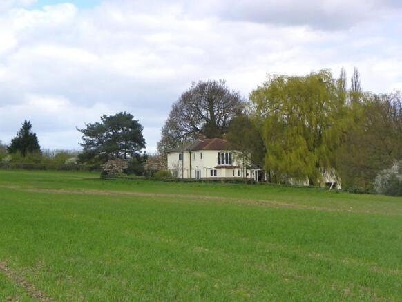 The house is surrounded by fields