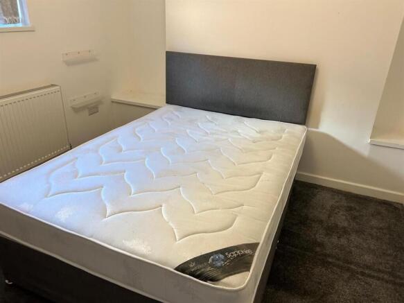 Bright double bedroom featuring a clean, modern...