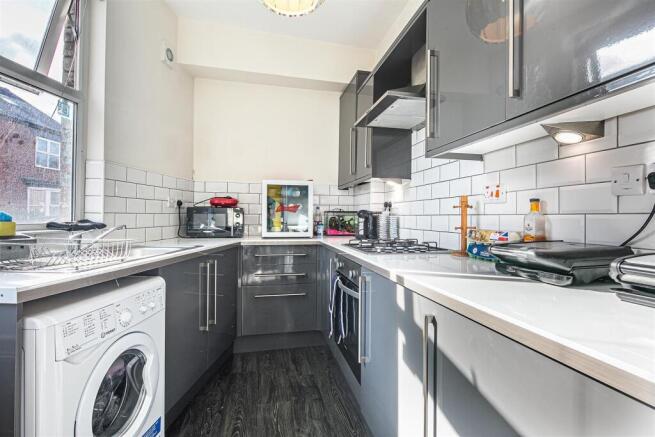 Modern kitchen with sleek grey units and tiling...