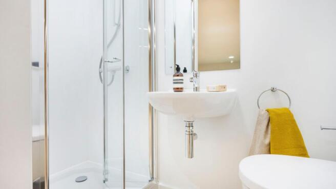 Bright, modern bathroom with a glass-enclosed s...