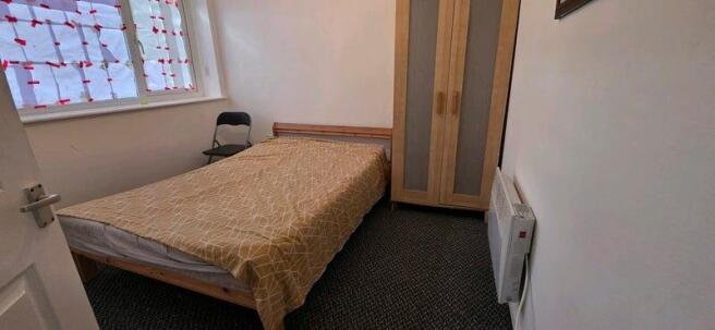 Simple, tidy bedroom with a single bed, wardrob...