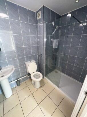 Modern bathroom suite featuring sleek dark tile...