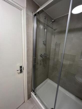 Modern bathroom featuring a fully enclosed glas...