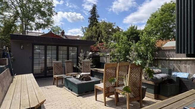 Expansive paved garden with stylish outdoor sea...