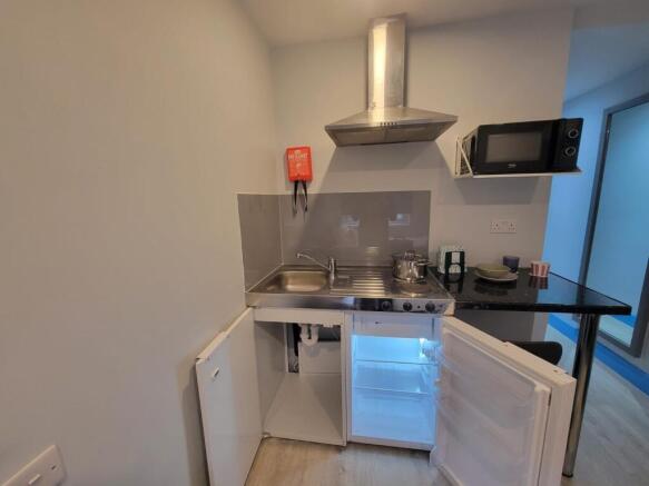 Compact modern kitchenette with stainless-steel...