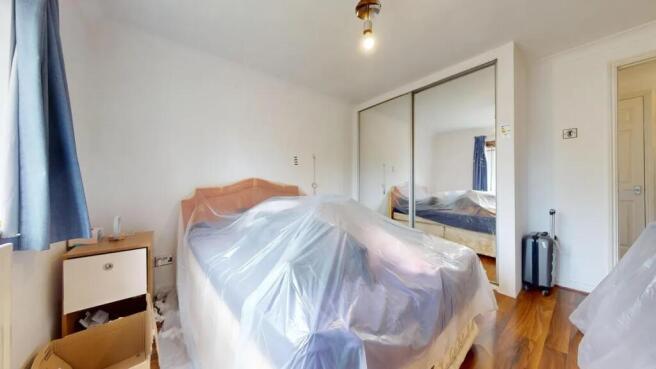 A well-lit double bedroom featuring a large bed...