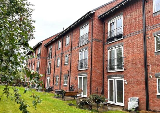 Well-maintained communal lawn and patio area be...