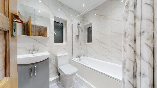Bright, modern bathroom with marble-effect tile...