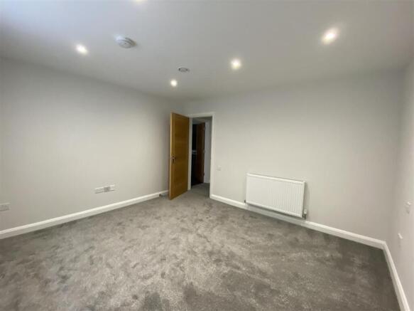 Spacious modern bedroom with plush grey carpet...