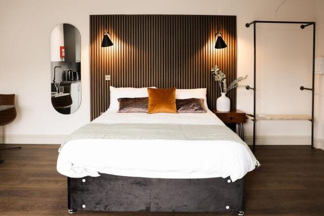 Stylish bedroom with feature wall and warm acce...