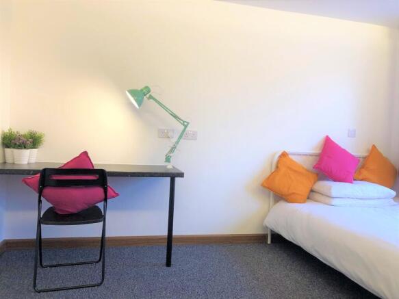 A bright and tidy single bedroom featuring a co...