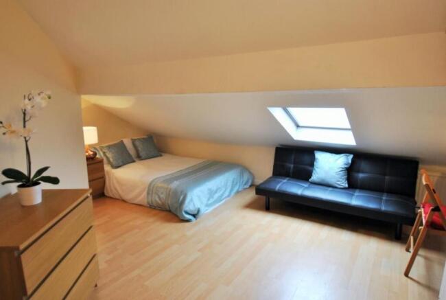 Bright attic bedroom with comfy sofa and desk...