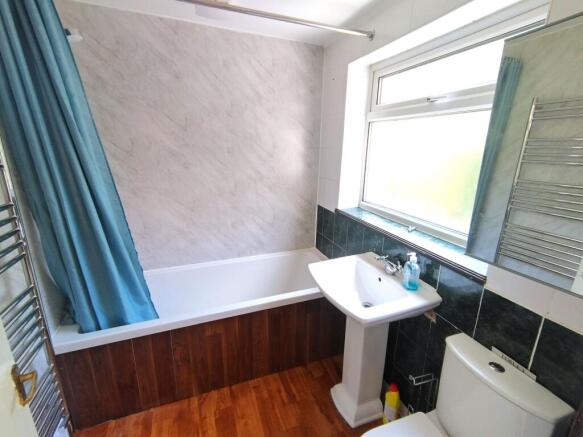 Bright, modern bathroom with a white bathtub, p...