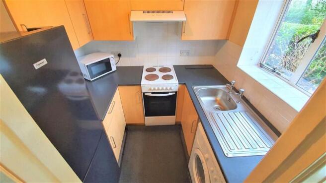 Bright kitchen with full appliances and window...