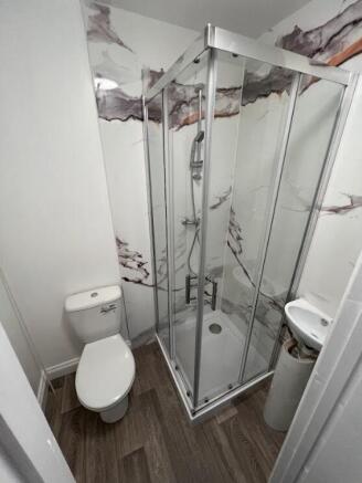 Bright, modern bathroom with a glass-enclosed c...