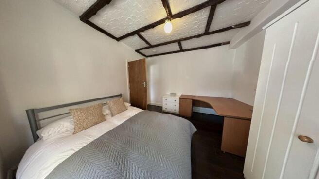 A cozy double bedroom featuring a large bed wit...