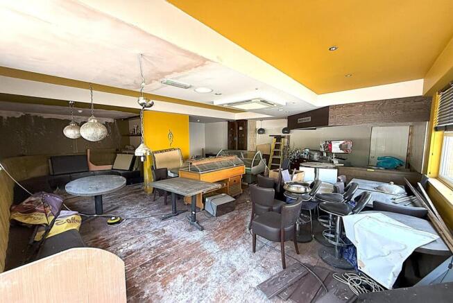 Spacious communal lounge with seating and brigh...