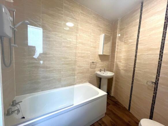 Modern tiled bathroom with a fitted bath and sh...