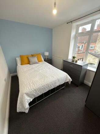 Bright and tidy double bedroom with a soft blue...